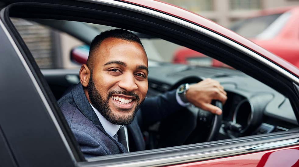 Buying a new car Griffin man driving car smiling